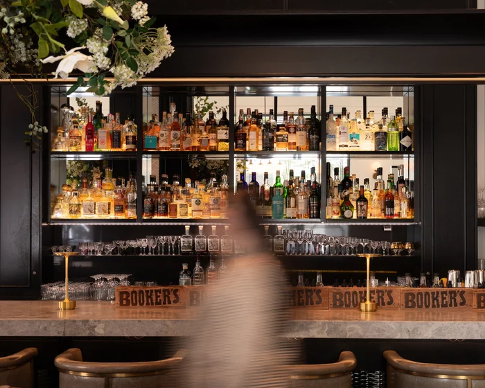 A woman walks in front of the bar at The Courtney Room