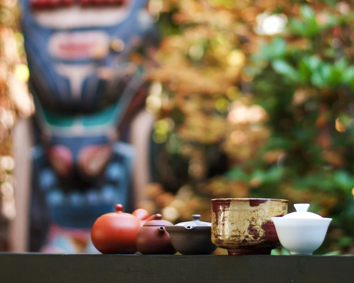 Teacups lined up with totem pole in the background at Nootka Court in Victoria