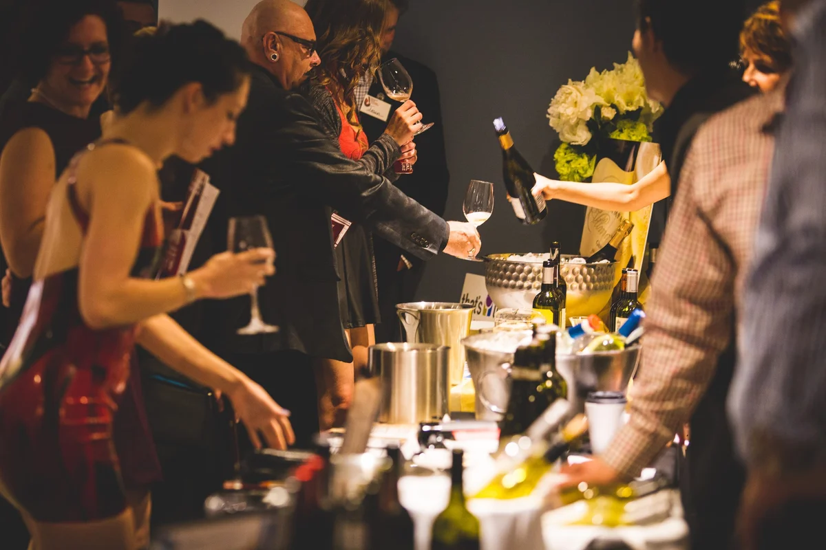 Booth at the Victoria International Wine Festival, people reaching for samples 