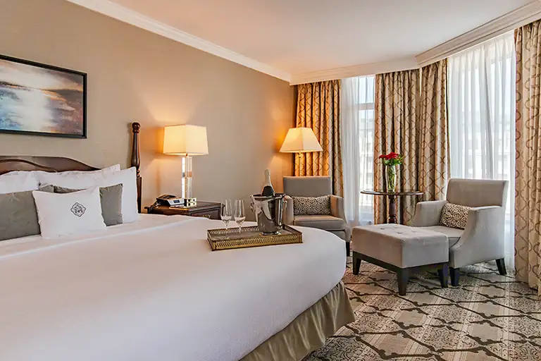 King Bed and Seating area of the Magnolia Hotel & Spa Deluxe Corner Guestroom