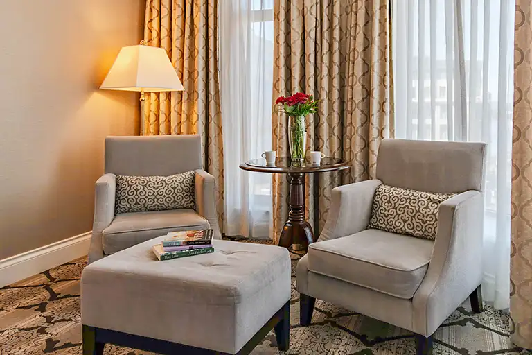 Seating area of the Magnolia Hotel & Spa Deluxe Corner Guestroom
