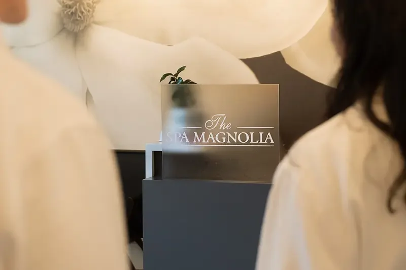 Back view of a couple in robes with the Spa Magnolia sign in focus
